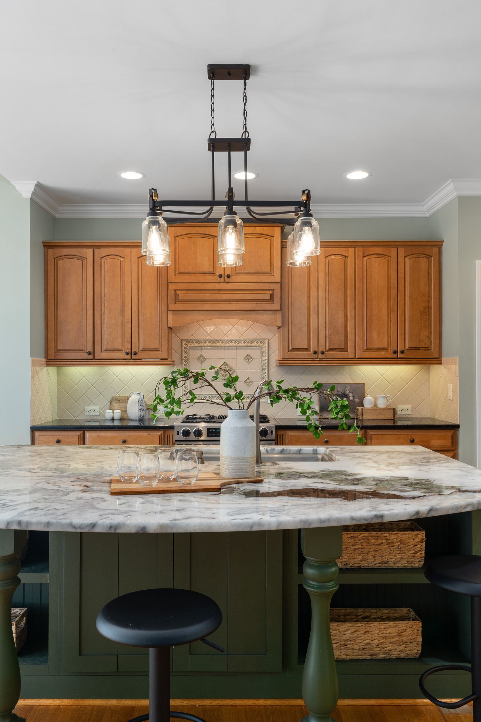 A modern kitchen with wood cabinets and a stone-topped island