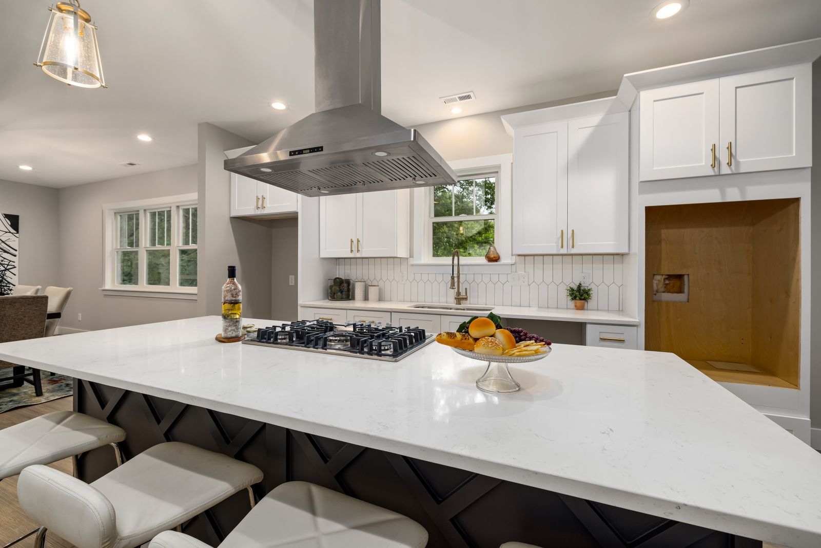 A finished modern kitchen with a large white island and marble counters